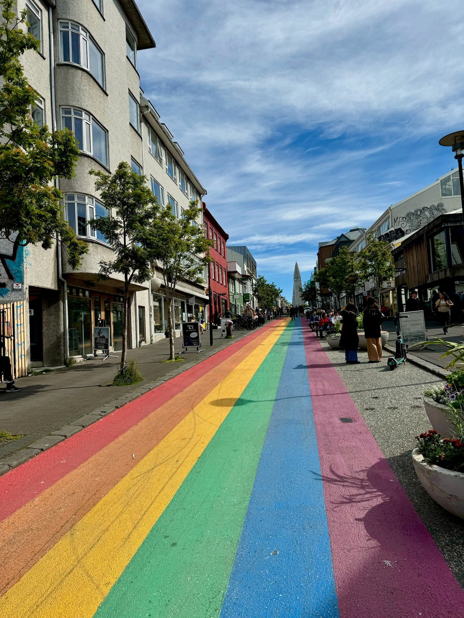 A Reykjavík, Iceland street painted with rainbow stripes under a blue sky