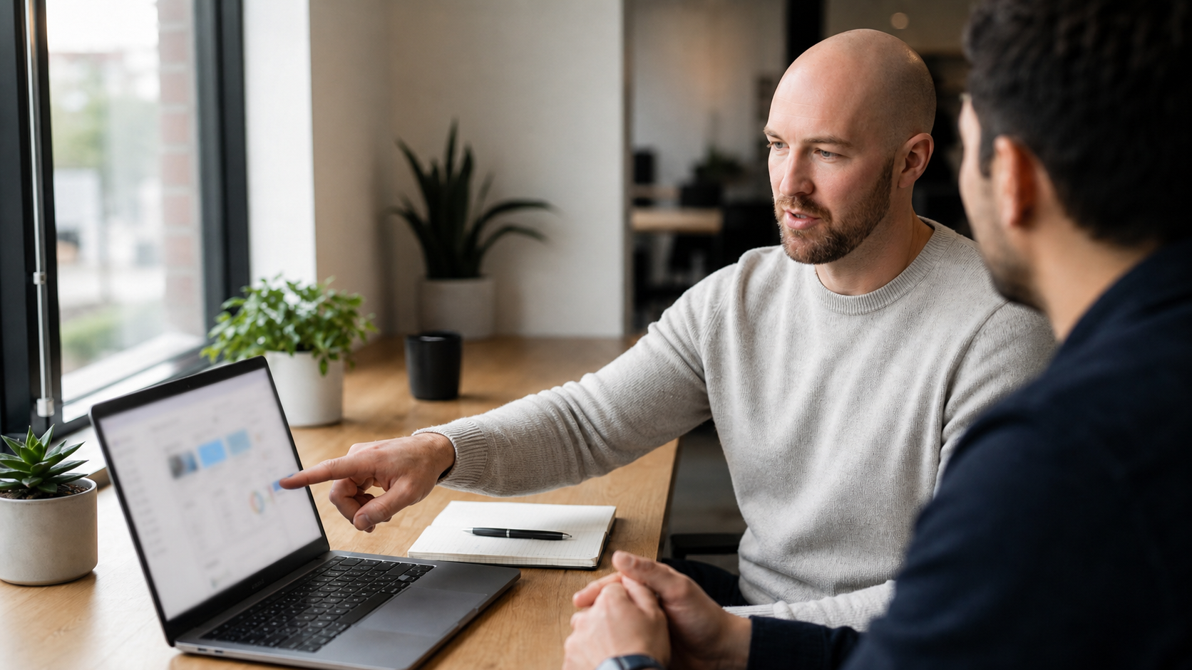 Julian Murphy reviewing a laptop screen with a colleague