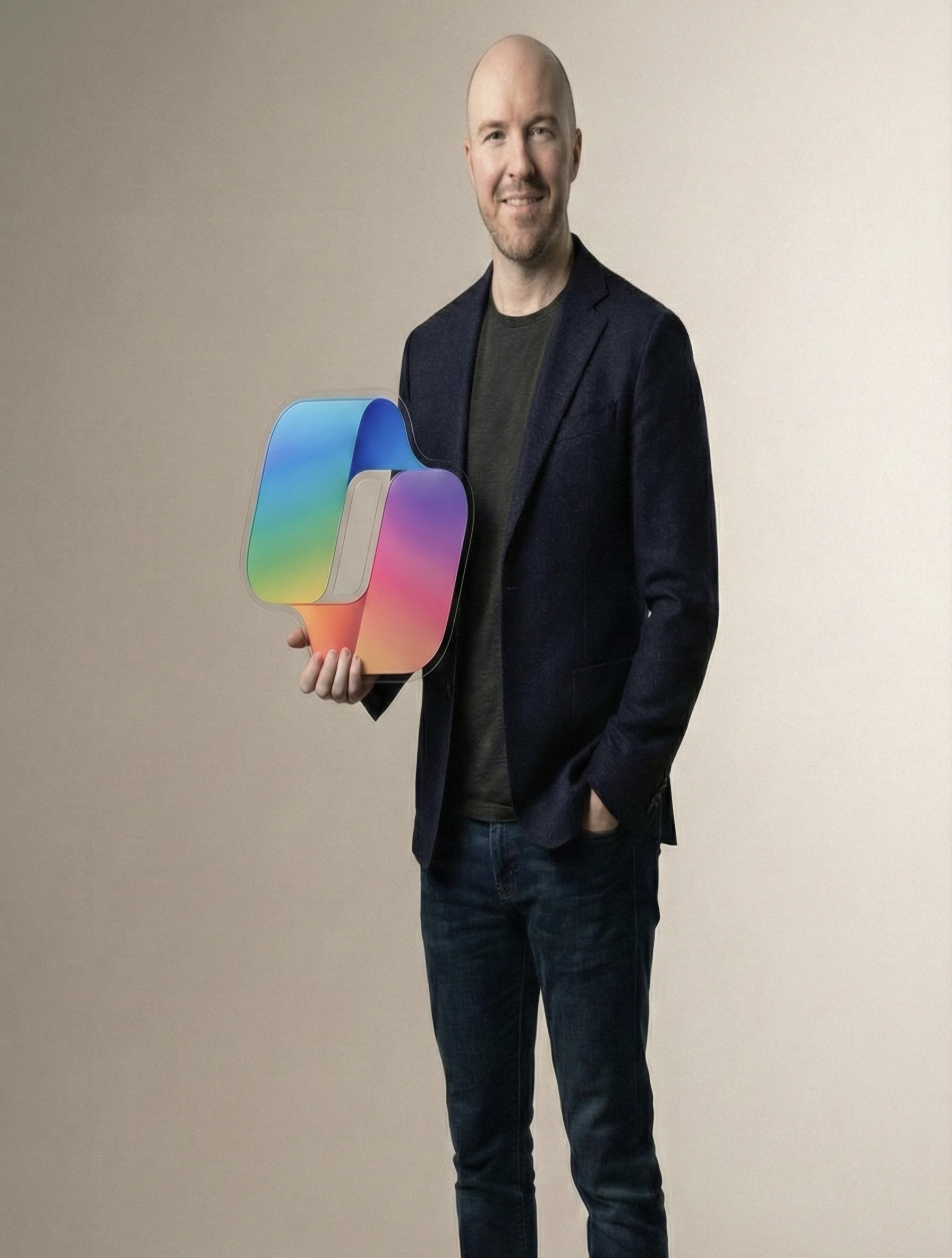 Julian Murphy holding a colorful Copilot logo made of glass
